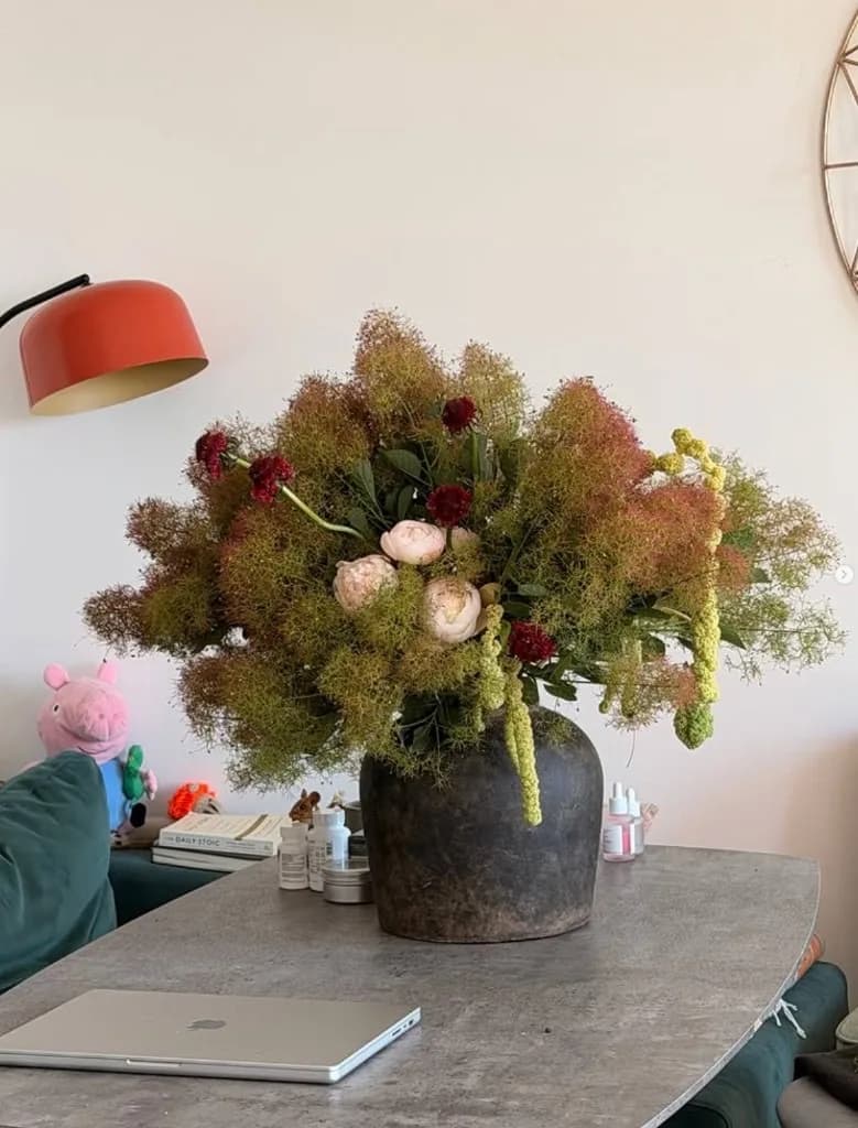 Smoke bush arrangement with peonies and amaranthus in a domestic setting
